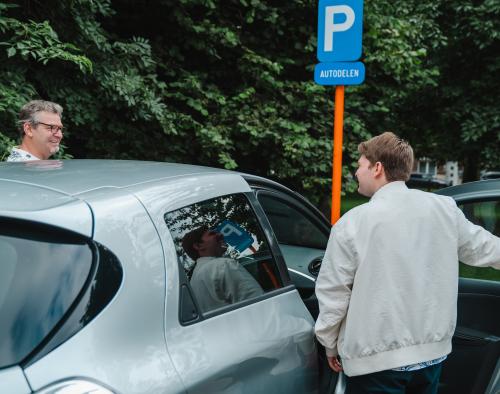 2 personen stappen in een deelauto