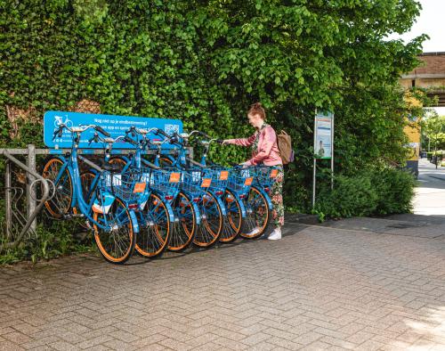 Vrouw plaatst deelfiets terug in fietsenstalling