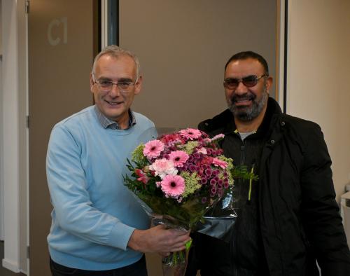 Loketmedewerker Rik geeft bloemen aan de 1.000ste loketbezoeker
