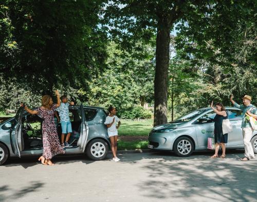 deelauto gezin staat klaar om met deelauto te vertrekken